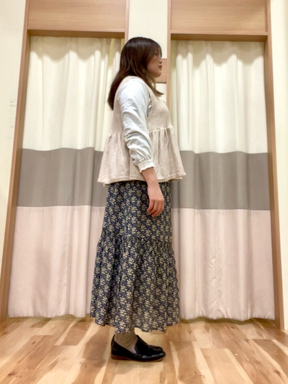 ホワイト系のシャツ/ブラウス、ブルー系のスカート、ホワイト系のベストを着用したレディースの冬コーディネートの2枚目の写真