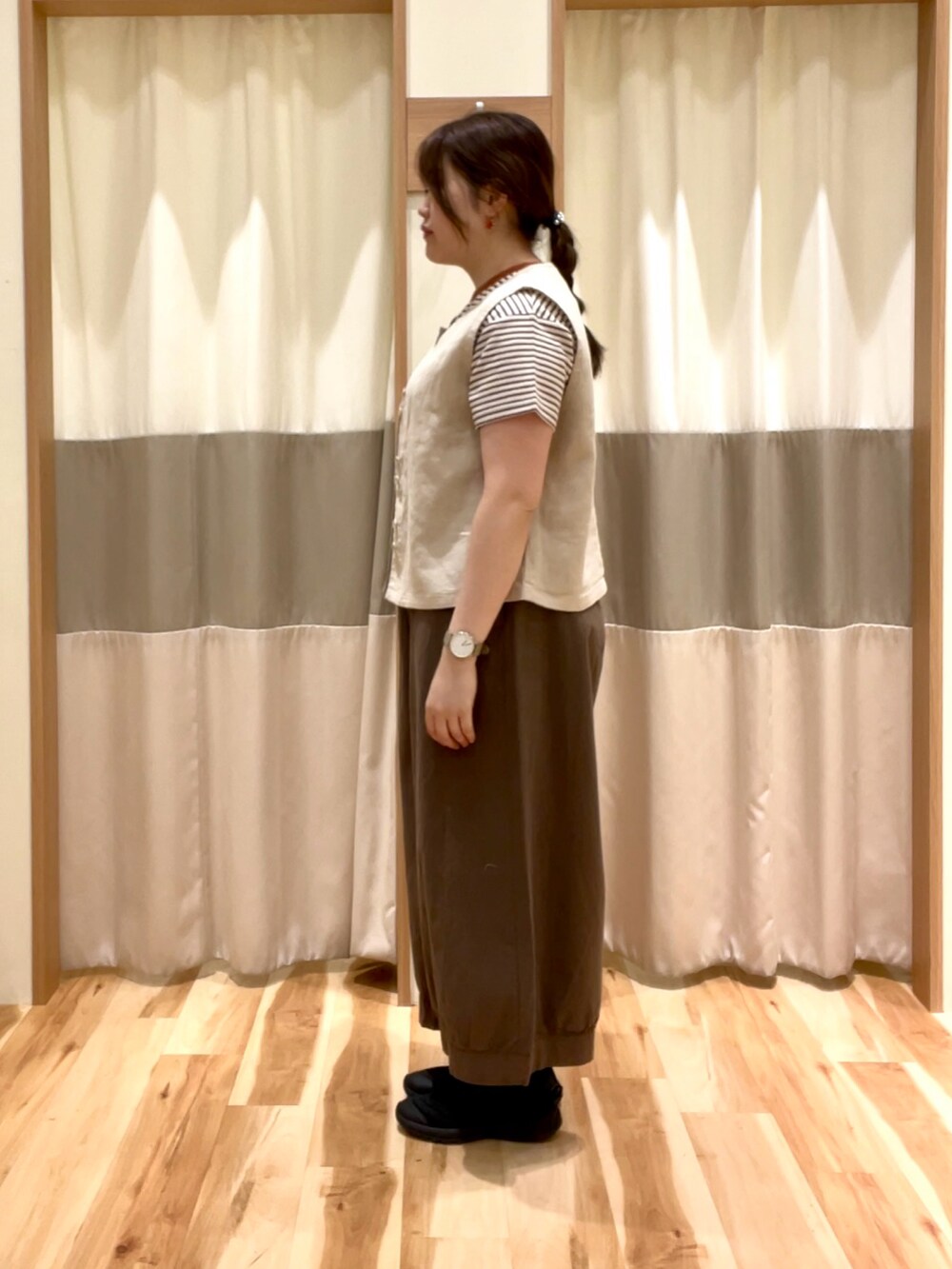 ブラウン系のその他パンツ、ベージュ系のベスト、ブラウン系のTシャツ/カットソーを着用したレディースの春コーディネートの2枚目の写真