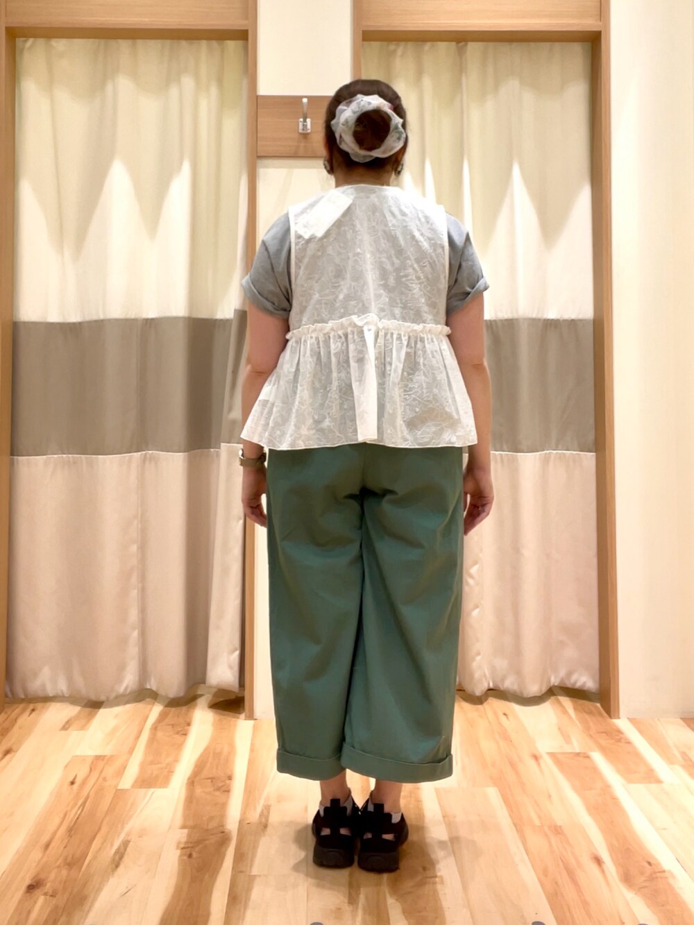 グレー系のTシャツ/カットソー、グリーン系のその他パンツ、ホワイト系のベストを着用したレディースの春コーディネートの3枚目の写真