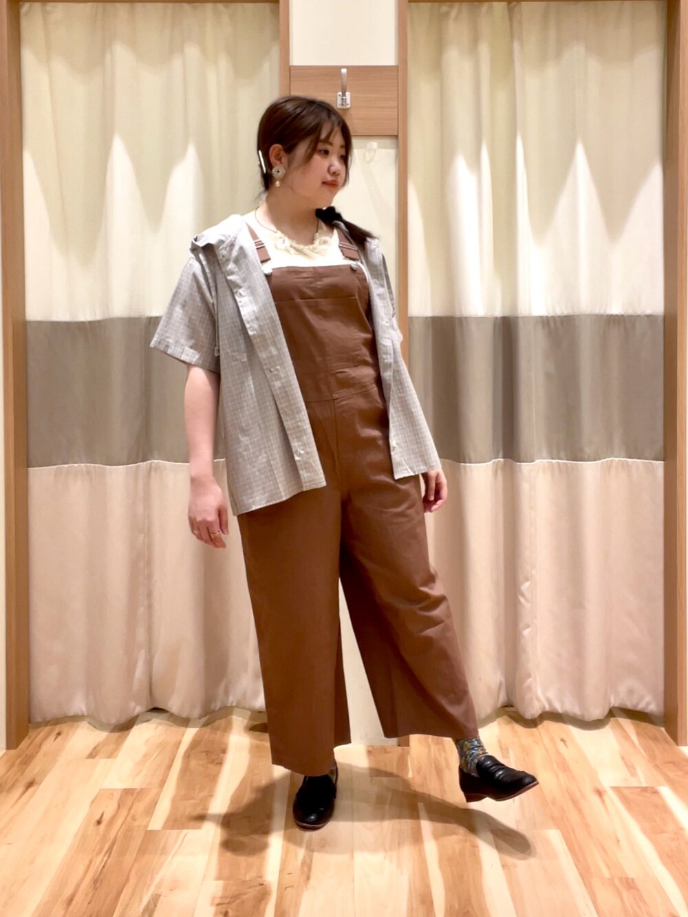 ブラウン系のオールインワン・サロペット、ホワイト系のタンクトップ、グレー系のシャツ/ブラウスを着用したレディースの春コーディネートの2枚目の写真