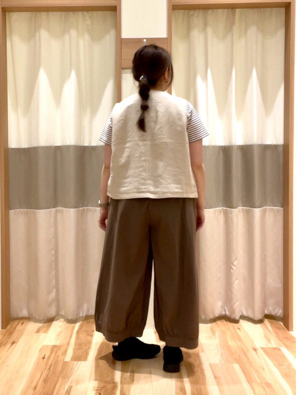 ブラウン系のその他パンツ、ベージュ系のベスト、ブラウン系のTシャツ/カットソーを着用したレディースの春コーディネートの3枚目の写真