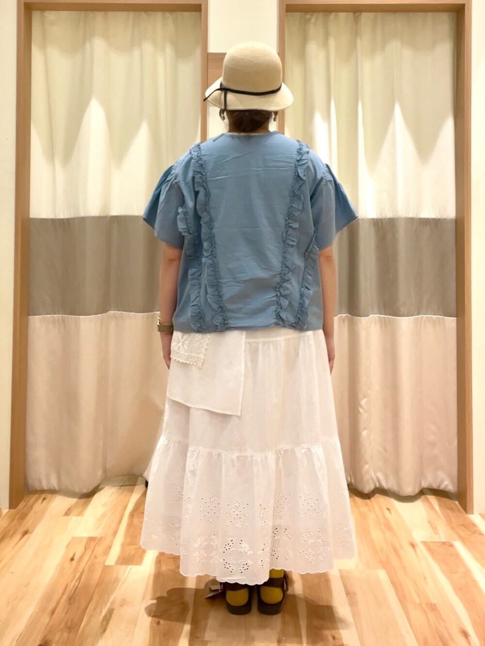 ホワイト系のスカート、ブルー系のシャツ/ブラウス、ホワイト系のTシャツ/カットソーを着用したレディースの春コーディネートの3枚目の写真