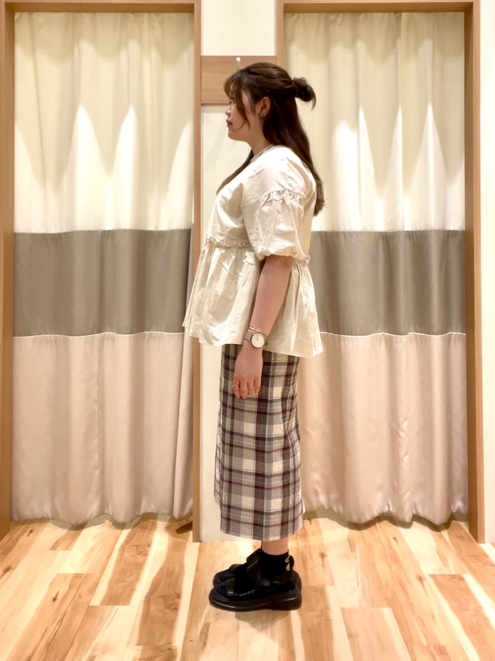 グレー系のスカート、ホワイト系のシャツ/ブラウスを着用したレディースの夏コーディネートの3枚目の写真