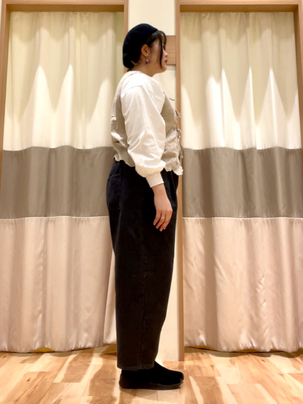 ブラック系のその他パンツ、ホワイト系のTシャツ/カットソー、ベージュ系のベストを着用したレディースの冬コーディネートの2枚目の写真
