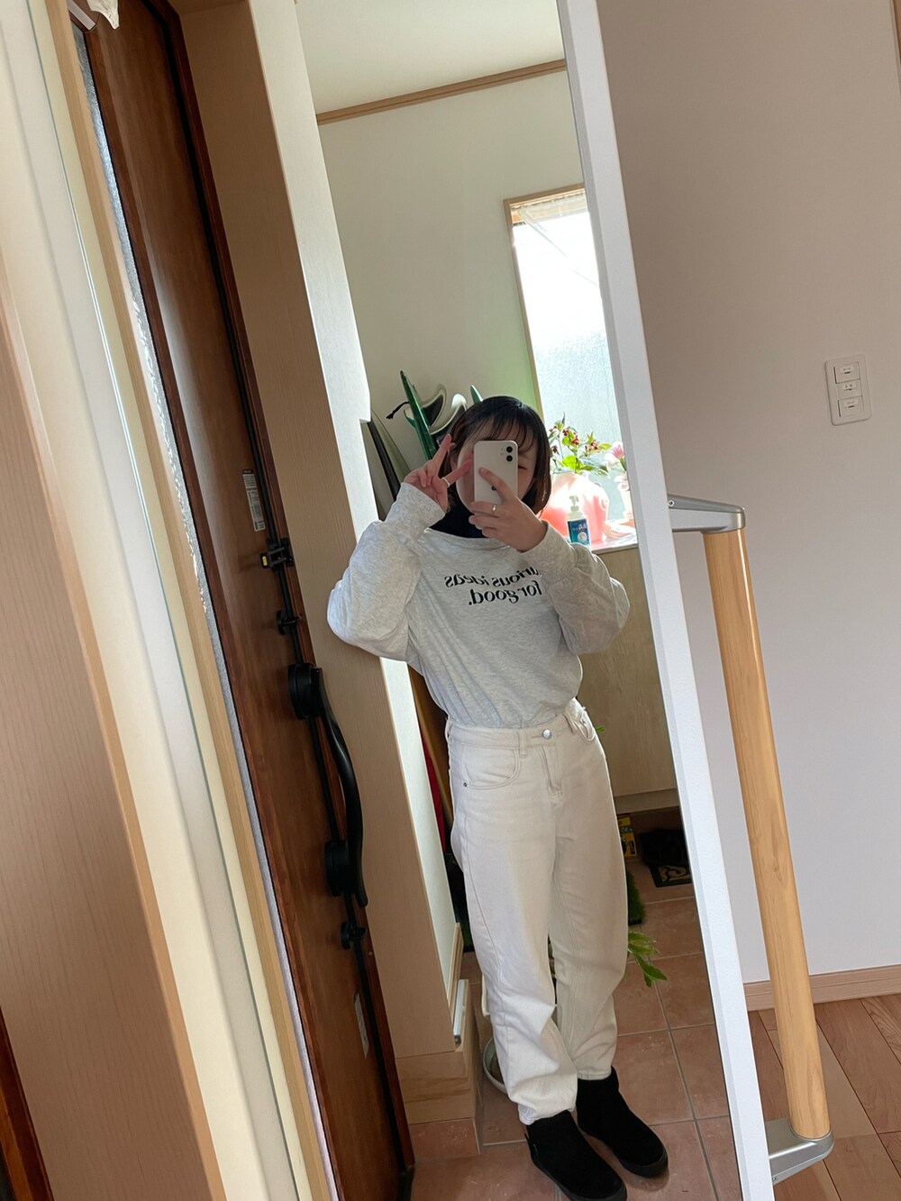 ベージュ系のデニムパンツ、ブラック系のニット/セーター、ホワイト系のリングを着用したレディースの冬コーディネートの2枚目の写真