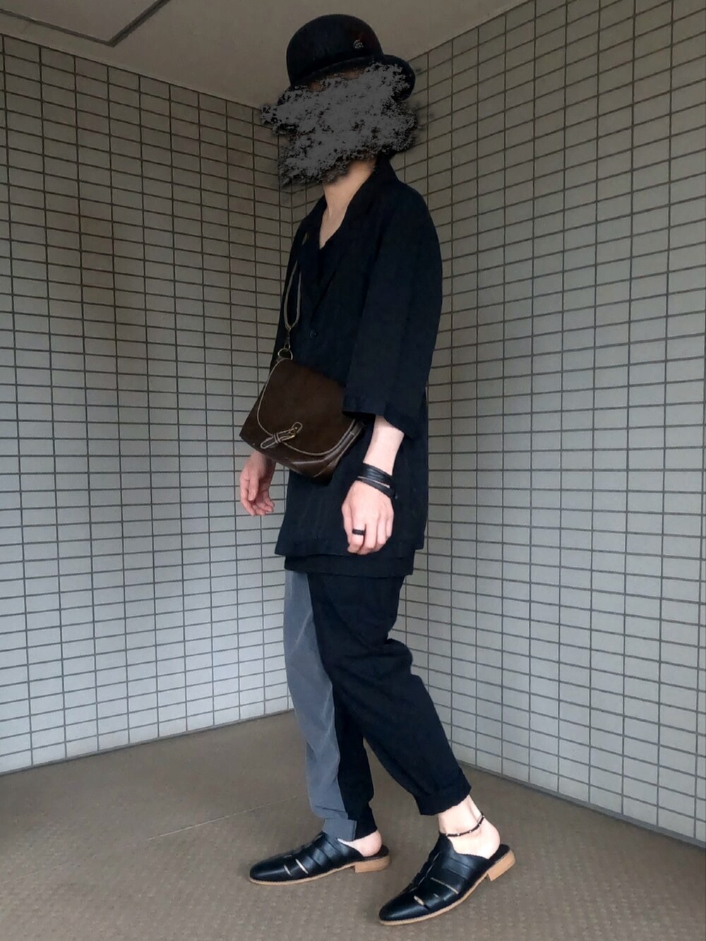 ブラック系のテーラードジャケット、ブラウン系のショルダーバッグ、グレー系のパンツを着用したメンズの夏コーディネートの3枚目の写真