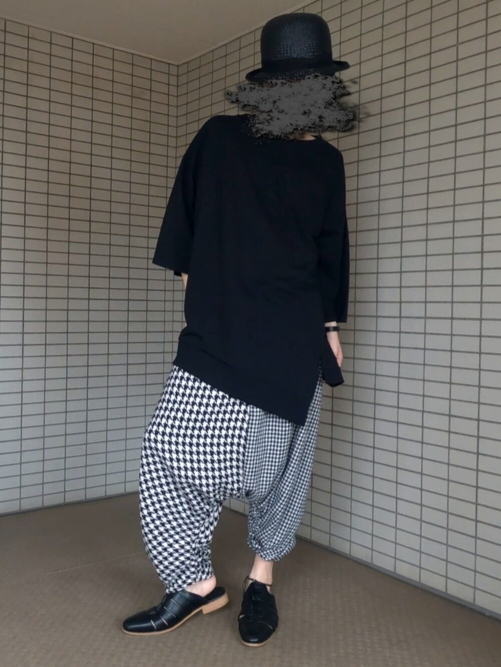 ブラック系のTシャツ/カットソー、ブラック系のボストンバッグ、ホワイト系のパンツを着用したメンズの夏コーディネートの5枚目の写真