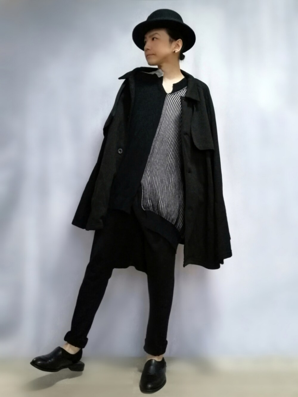 ブラック系のポンチョ、ブラック系のニット/セーター、ブラック系のその他パンツを着用したメンズの秋コーディネートの2枚目の写真