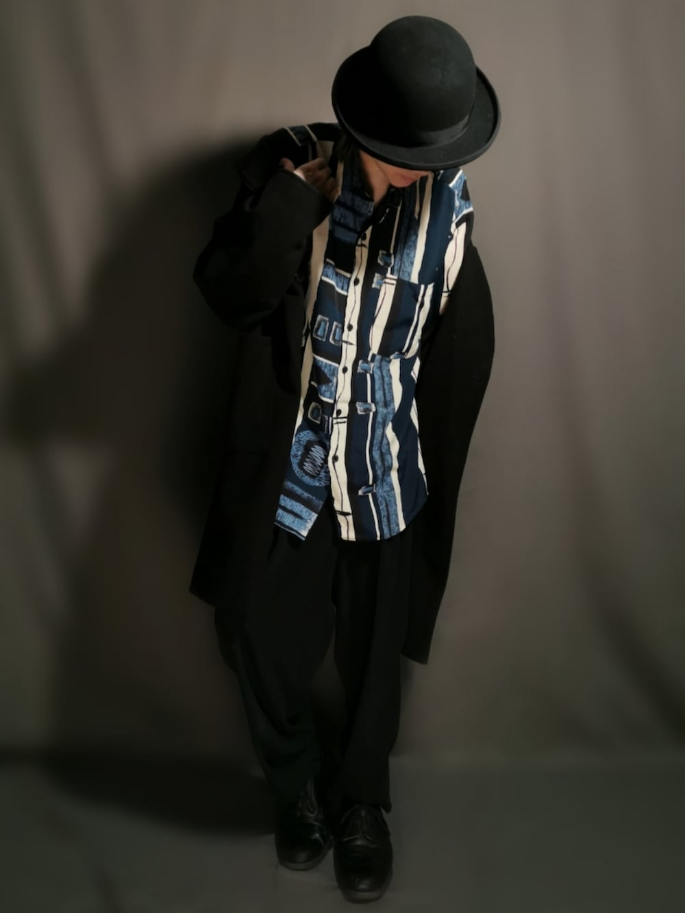 ブラック系のチェスターコート、ブルー系のシャツ/ブラウス、ブラック系のその他パンツを着用したメンズの春コーディネートの2枚目の写真