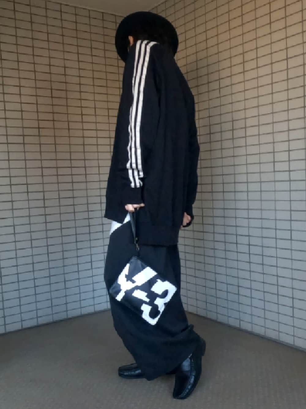 ブラック系のTシャツ/カットソー、ホワイト系のタンクトップ、ブラック系のクラッチバッグを着用したメンズの春コーディネートの4枚目の写真