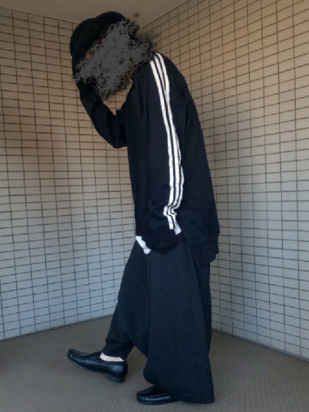 ブラック系のTシャツ/カットソー、ホワイト系のタンクトップ、ブラック系のクラッチバッグを着用したメンズの春コーディネートの2枚目の写真