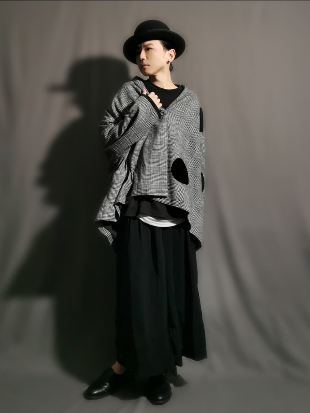 グレー系のポンチョ、ブラック系のサンダル、ブラック系のスカートを着用したメンズの冬コーディネートの3枚目の写真