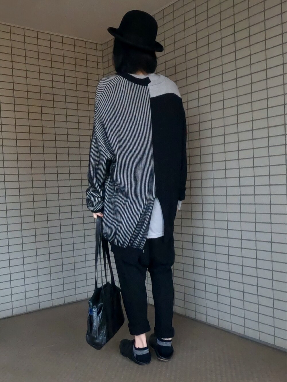 ブラック系のニット/セーター、ブラック系のボストンバッグ、ブラック系のスリッポンを着用したメンズの秋コーディネートの4枚目の写真