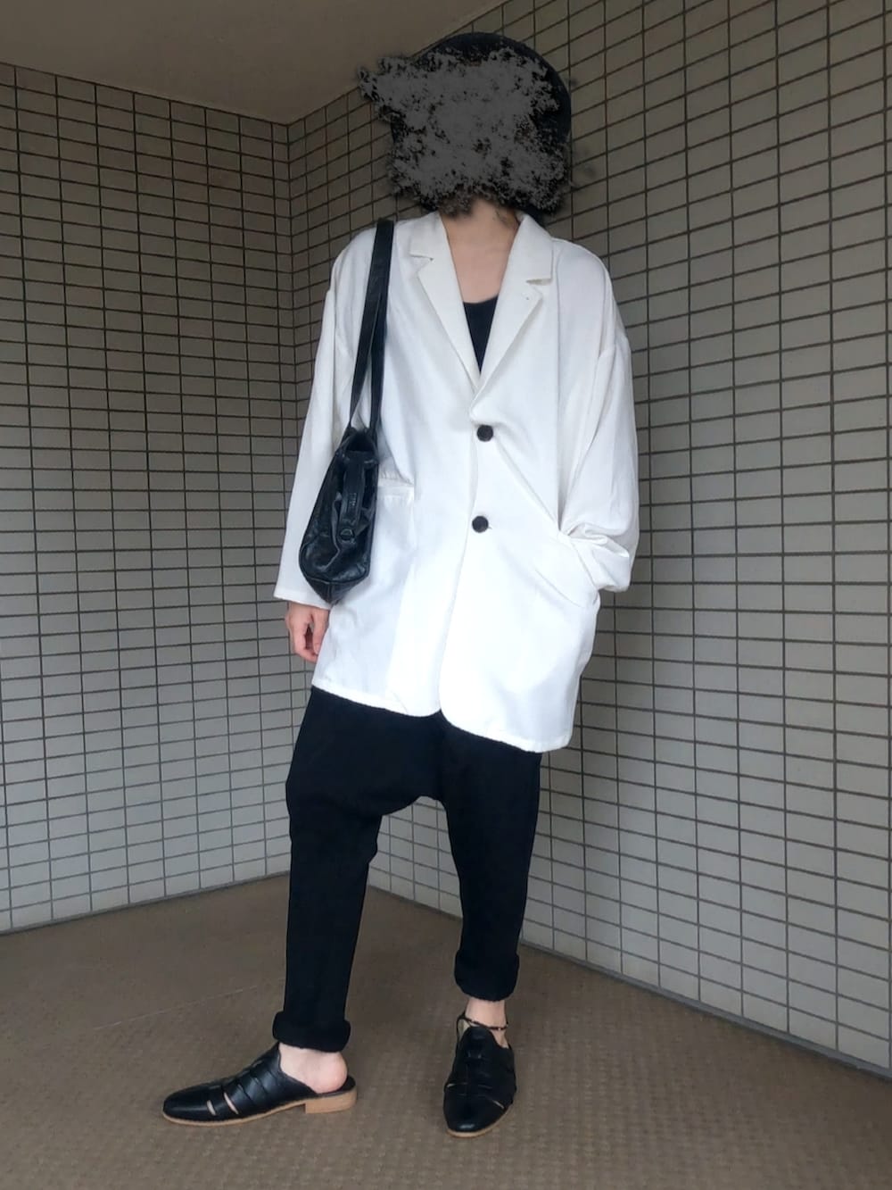 ホワイト系のテーラードジャケット、ブラック系のボストンバッグ、ブラック系のサンダルを着用したメンズの秋コーディネートの2枚目の写真