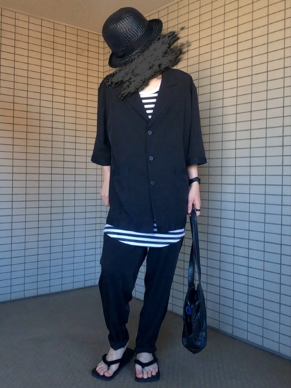 ブラック系のテーラードジャケット、ホワイト系のタンクトップ、ブラック系のパンツを着用したメンズの夏コーディネートの2枚目の写真