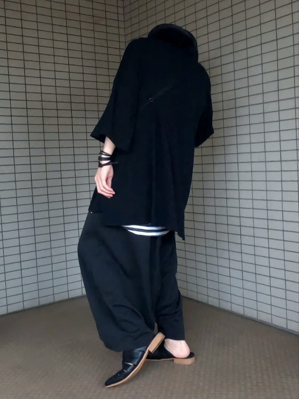 ブラック系のTシャツ/カットソー、ブラック系のその他パンツ、ブラック系のサンダルを着用したメンズの秋コーディネートの4枚目の写真