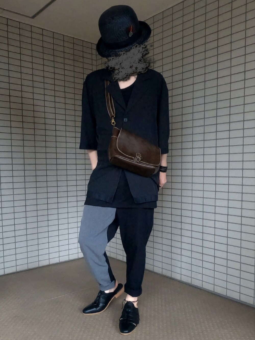 ブラック系のテーラードジャケット、ブラウン系のショルダーバッグ、グレー系のパンツを着用したメンズの夏コーディネートの4枚目の写真