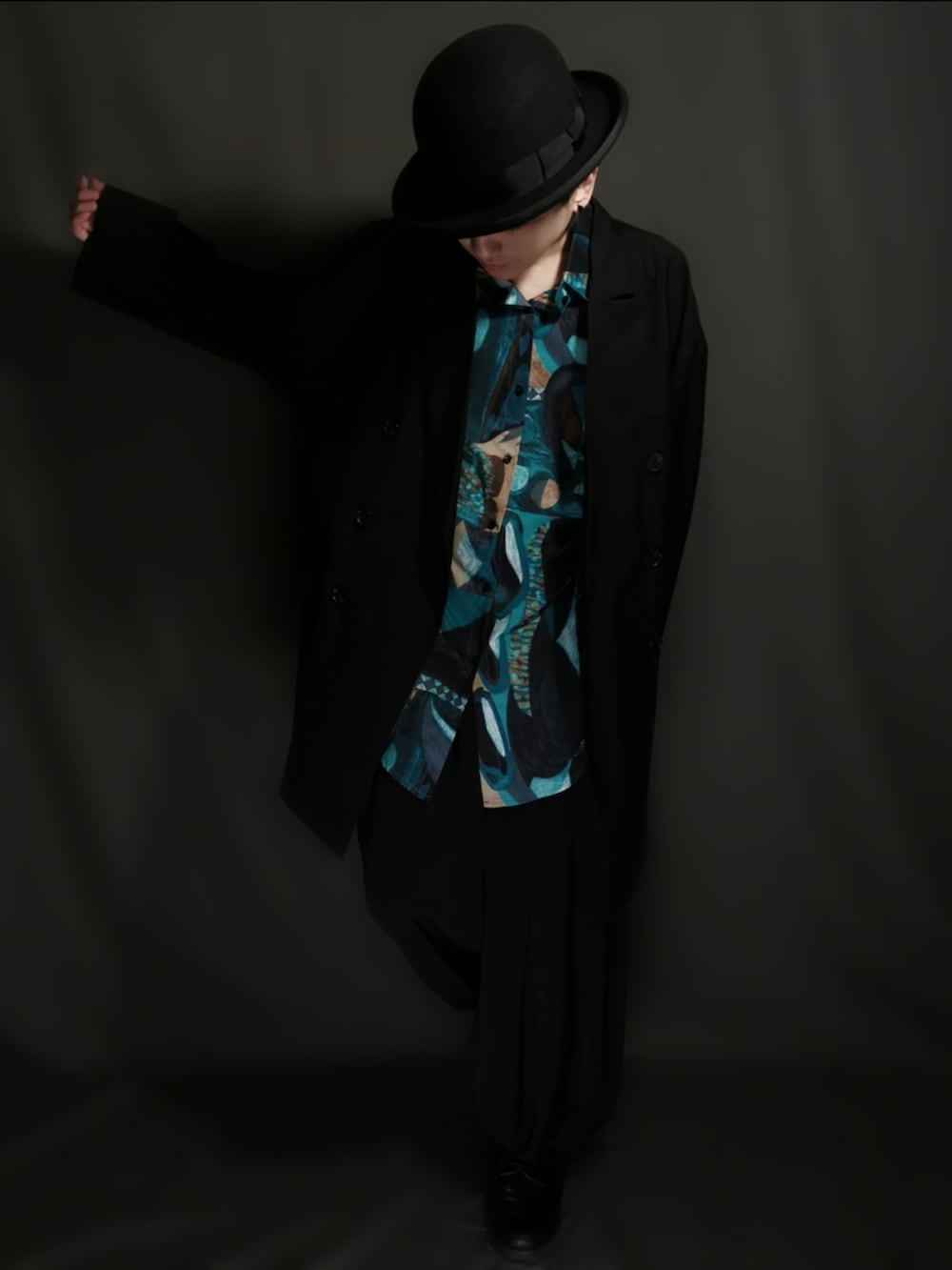 ブラック系のテーラードジャケット、ブラック系のスカート、ブラック系のドレスシューズを着用したメンズの冬コーディネートの3枚目の写真