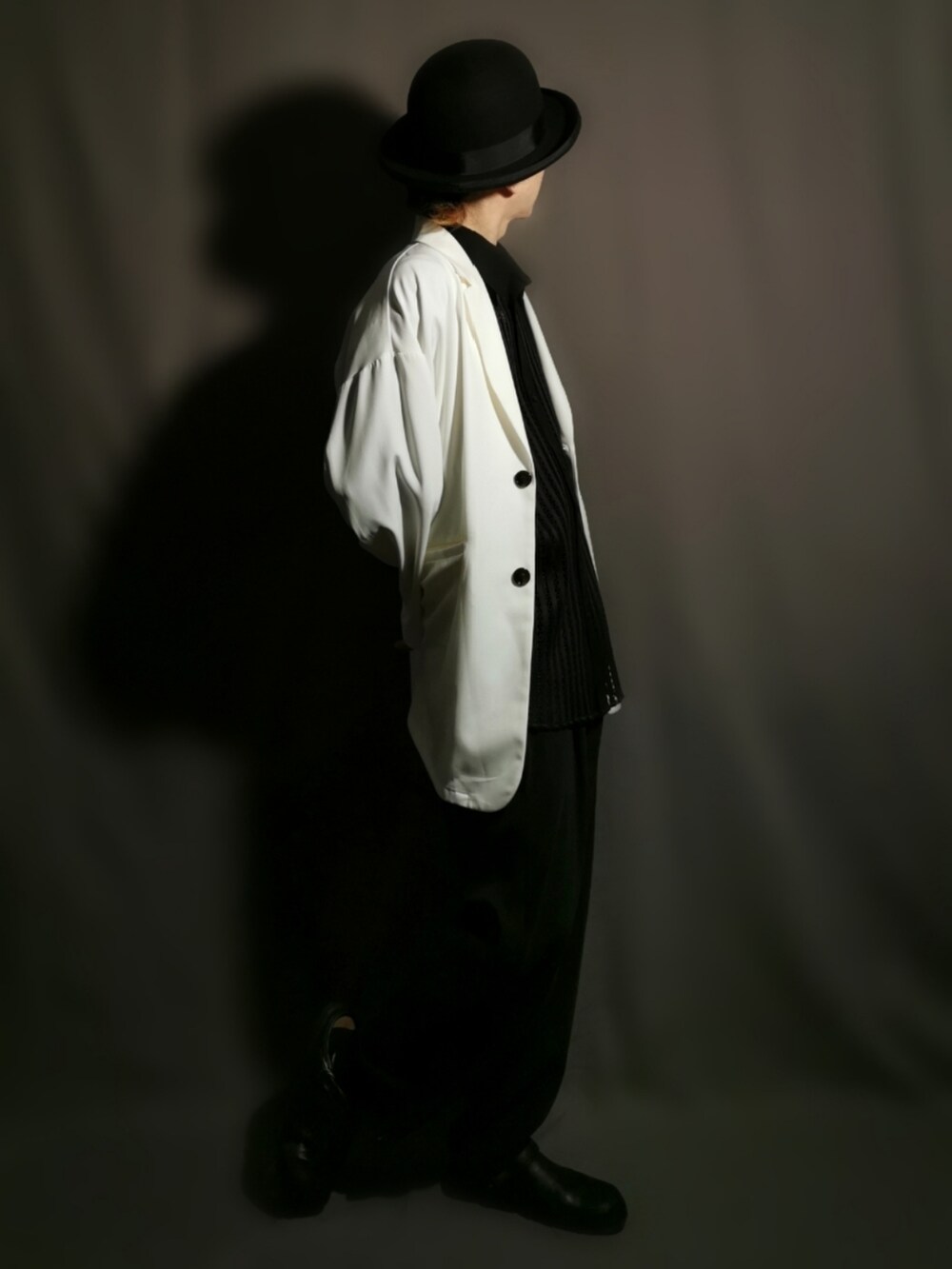 ホワイト系のテーラードジャケット、ブラック系のシャツ/ブラウス、ブラック系のスリッポンを着用したメンズの秋コーディネートの4枚目の写真