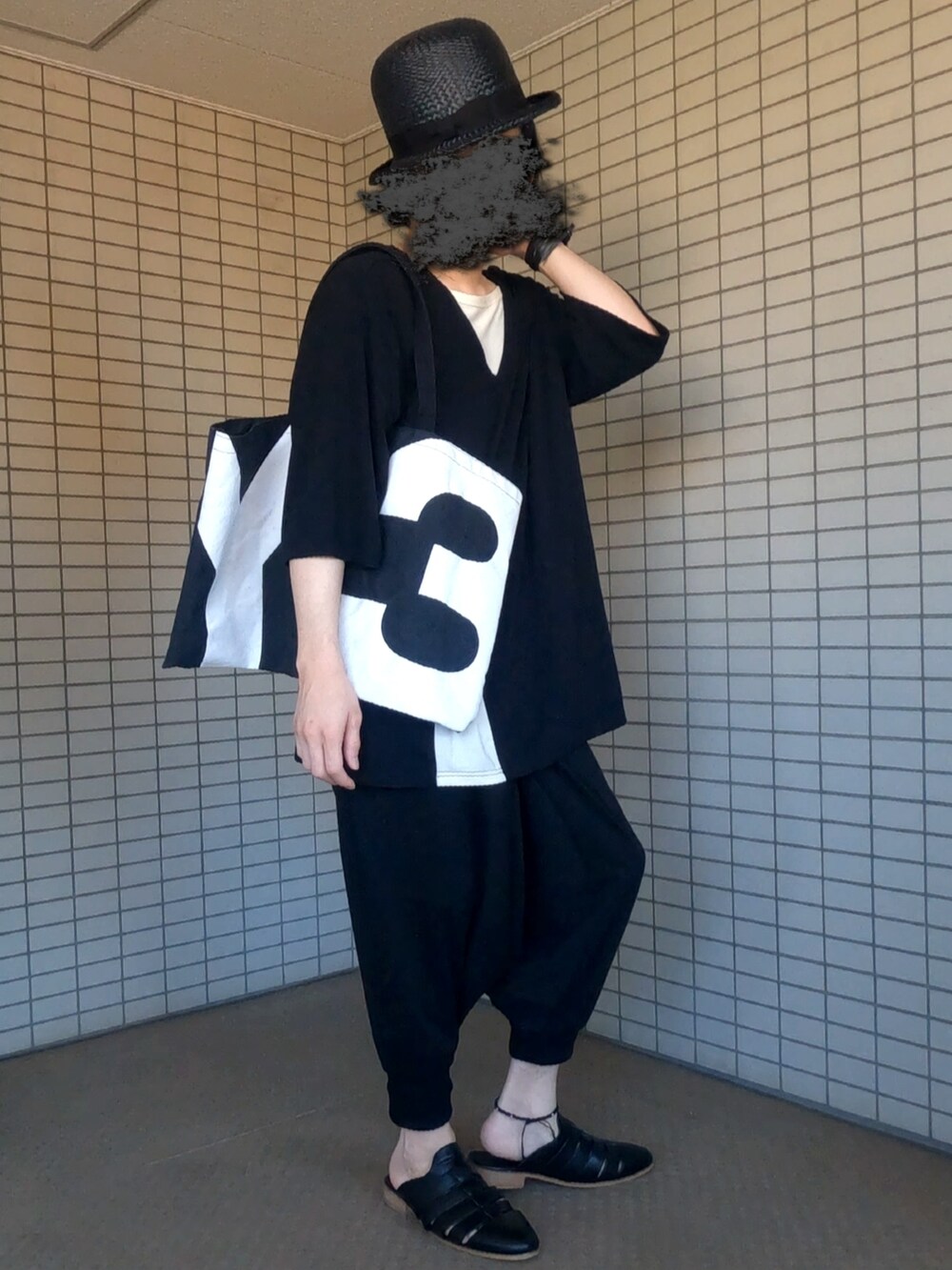 ブラック系のトートバッグ、ブラック系のTシャツ/カットソー、ブラック系のその他パンツを着用したメンズの夏コーディネートの3枚目の写真