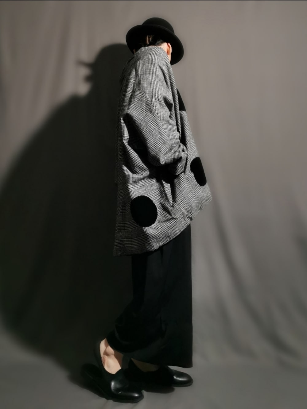 グレー系のポンチョ、ブラック系のサンダル、ブラック系のスカートを着用したメンズの冬コーディネートの2枚目の写真