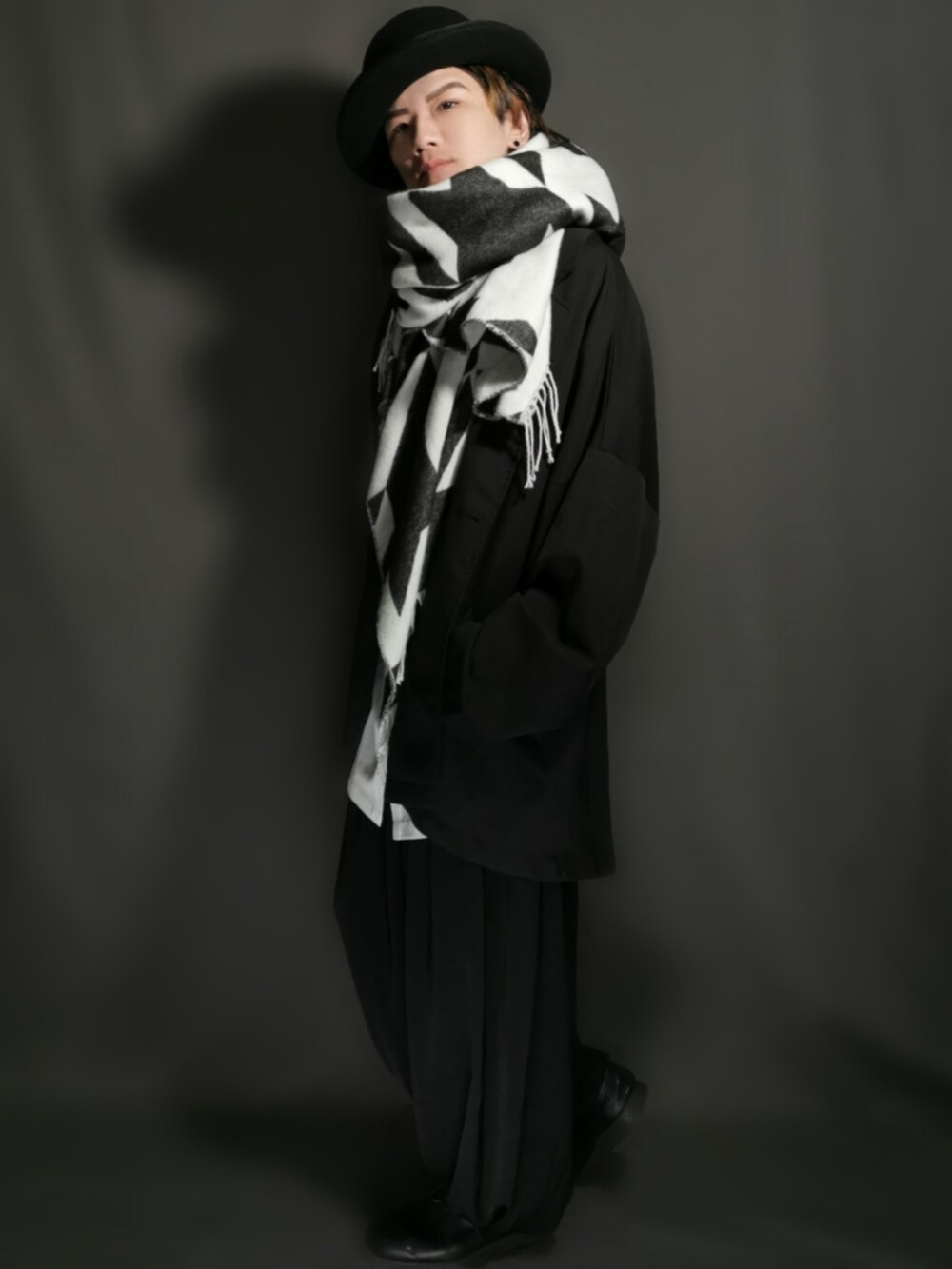 ブラック系のテーラードジャケット、ホワイト系のシャツ/ブラウス、ブラック系のスカートを着用したメンズの冬コーディネートの3枚目の写真