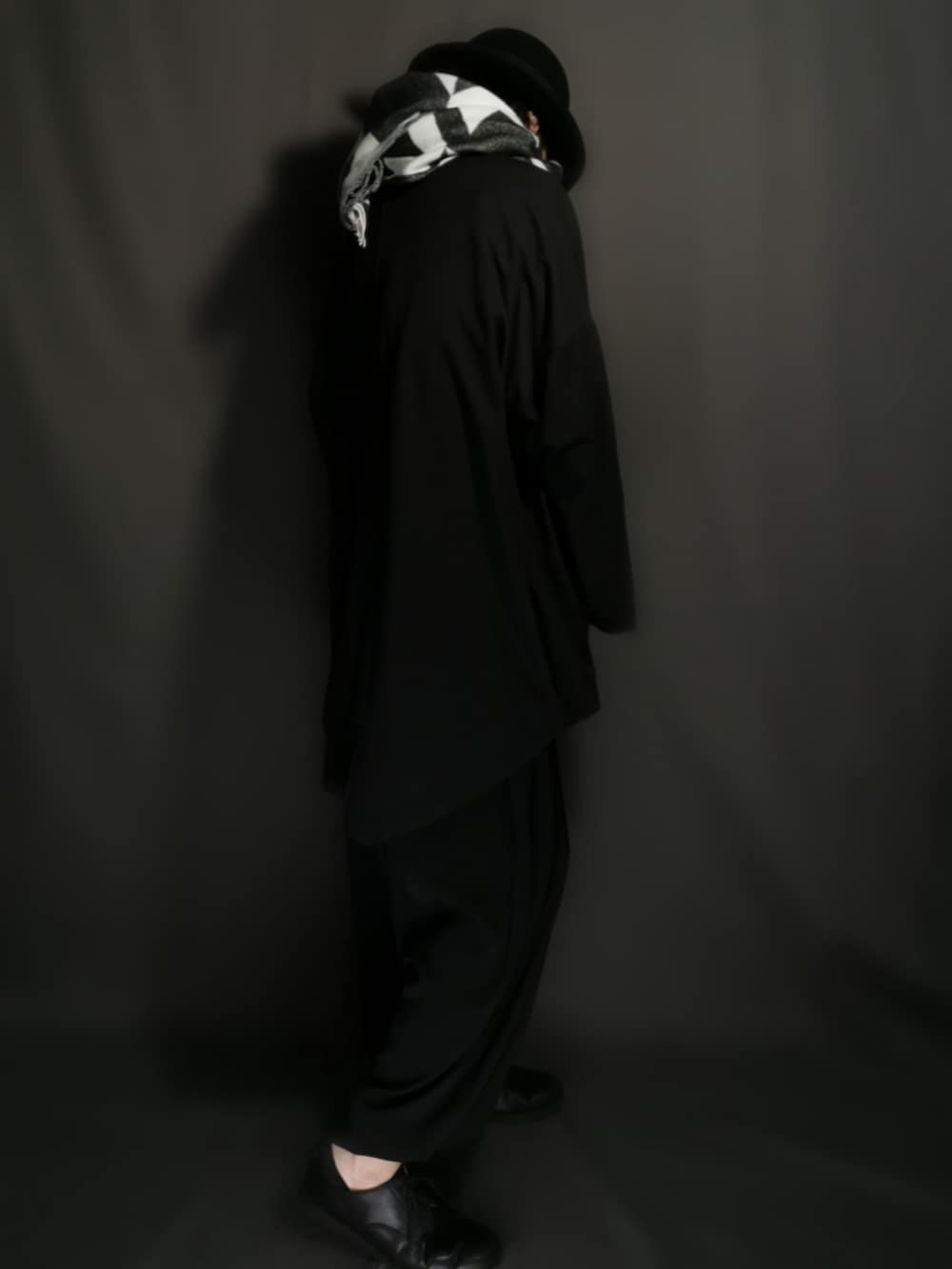 ブラック系のテーラードジャケット、ホワイト系のシャツ/ブラウス、ブラック系のスカートを着用したメンズの冬コーディネートの4枚目の写真