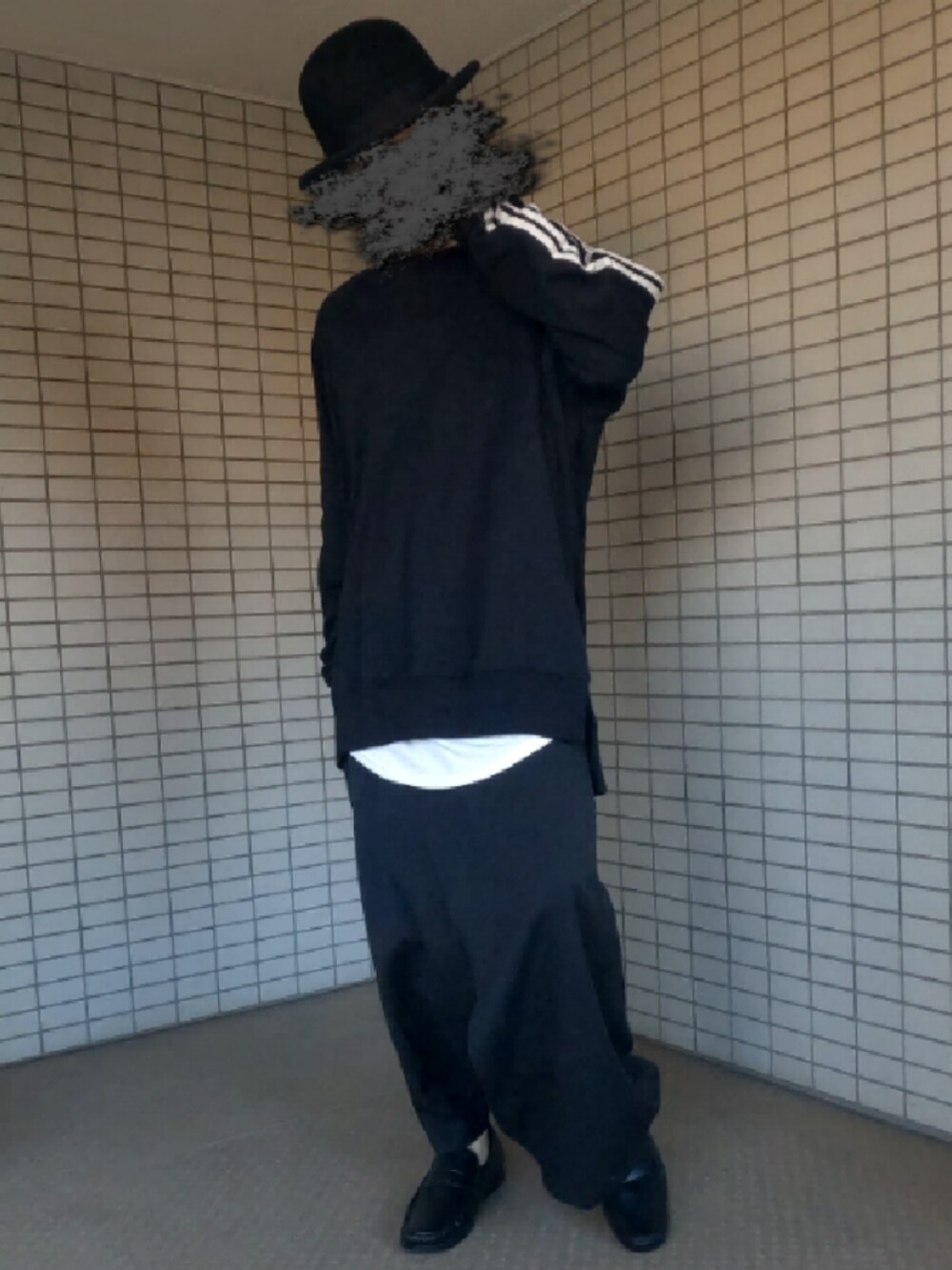 ブラック系のTシャツ/カットソー、ホワイト系のタンクトップ、ブラック系のクラッチバッグを着用したメンズの春コーディネートの3枚目の写真