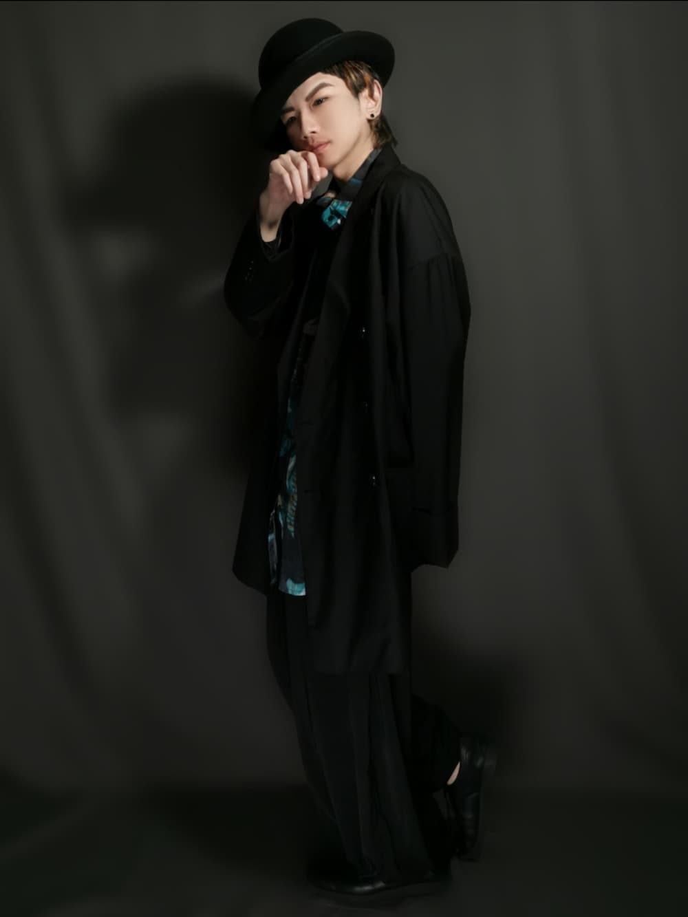 ブラック系のテーラードジャケット、ブラック系のスカート、ブラック系のドレスシューズを着用したメンズの冬コーディネートの2枚目の写真