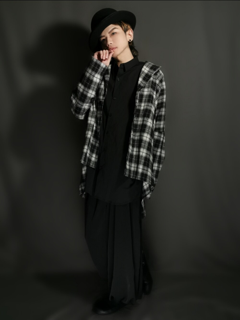 ブラック系のテーラードジャケット、ブラック系のシャツ/ブラウス、ブラック系のスカートを着用したメンズの秋コーディネートの2枚目の写真