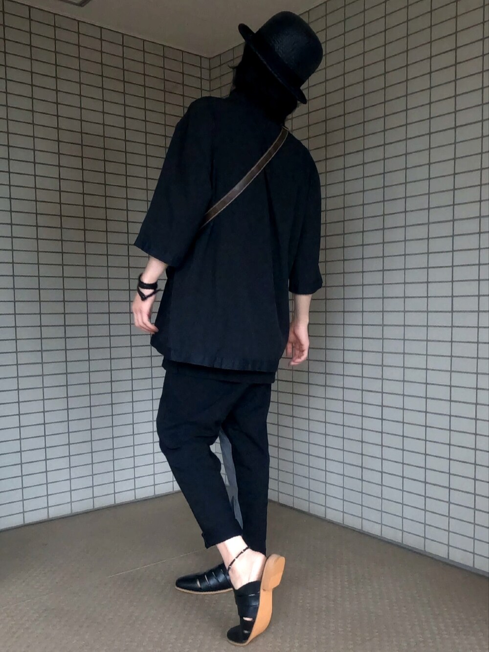 ブラック系のテーラードジャケット、ブラウン系のショルダーバッグ、グレー系のパンツを着用したメンズの夏コーディネートの5枚目の写真