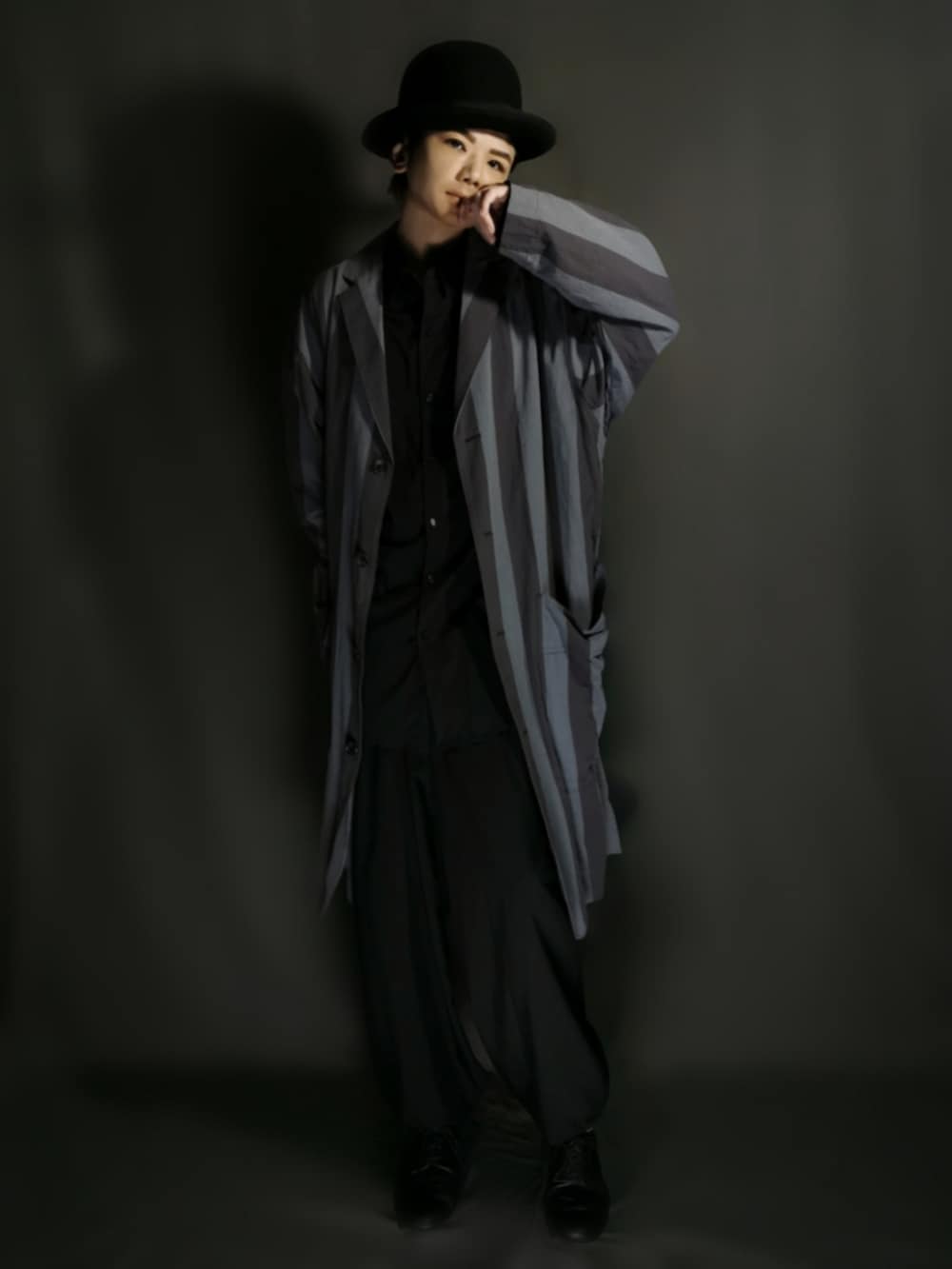 グレー系のチェスターコート、ブラック系のシャツ/ブラウス、ブラック系のセットアップを着用したメンズの秋コーディネートの2枚目の写真