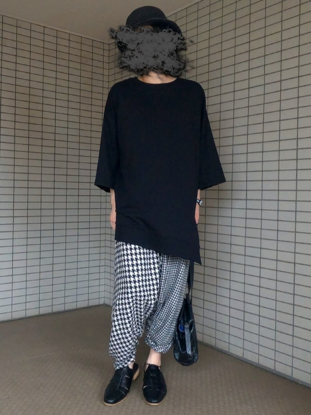 ブラック系のTシャツ/カットソー、ブラック系のボストンバッグ、ホワイト系のパンツを着用したメンズの夏コーディネートの2枚目の写真