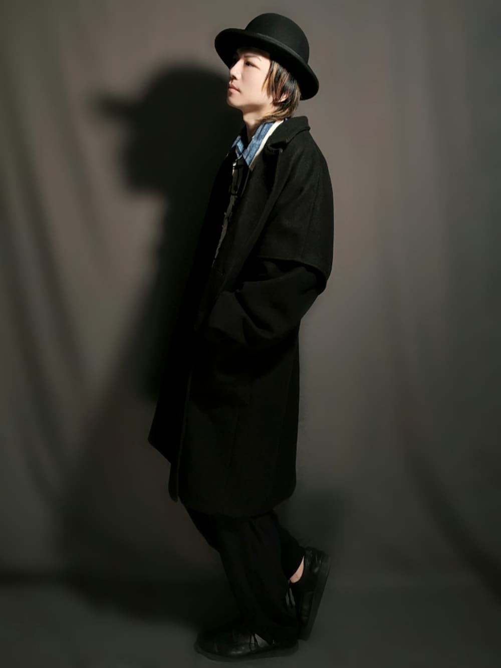 ブラック系のチェスターコート、ブルー系のシャツ/ブラウス、ブラック系のその他パンツを着用したメンズの春コーディネートの4枚目の写真