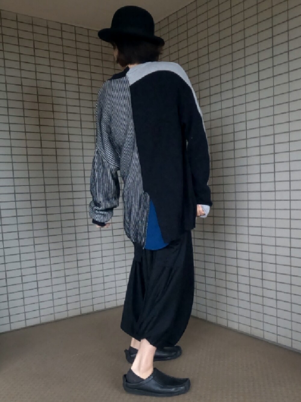 ブラック系のニット/セーター、ブラック系のショルダーバッグ、ブラック系のスリッポンを着用したメンズの春コーディネートの4枚目の写真