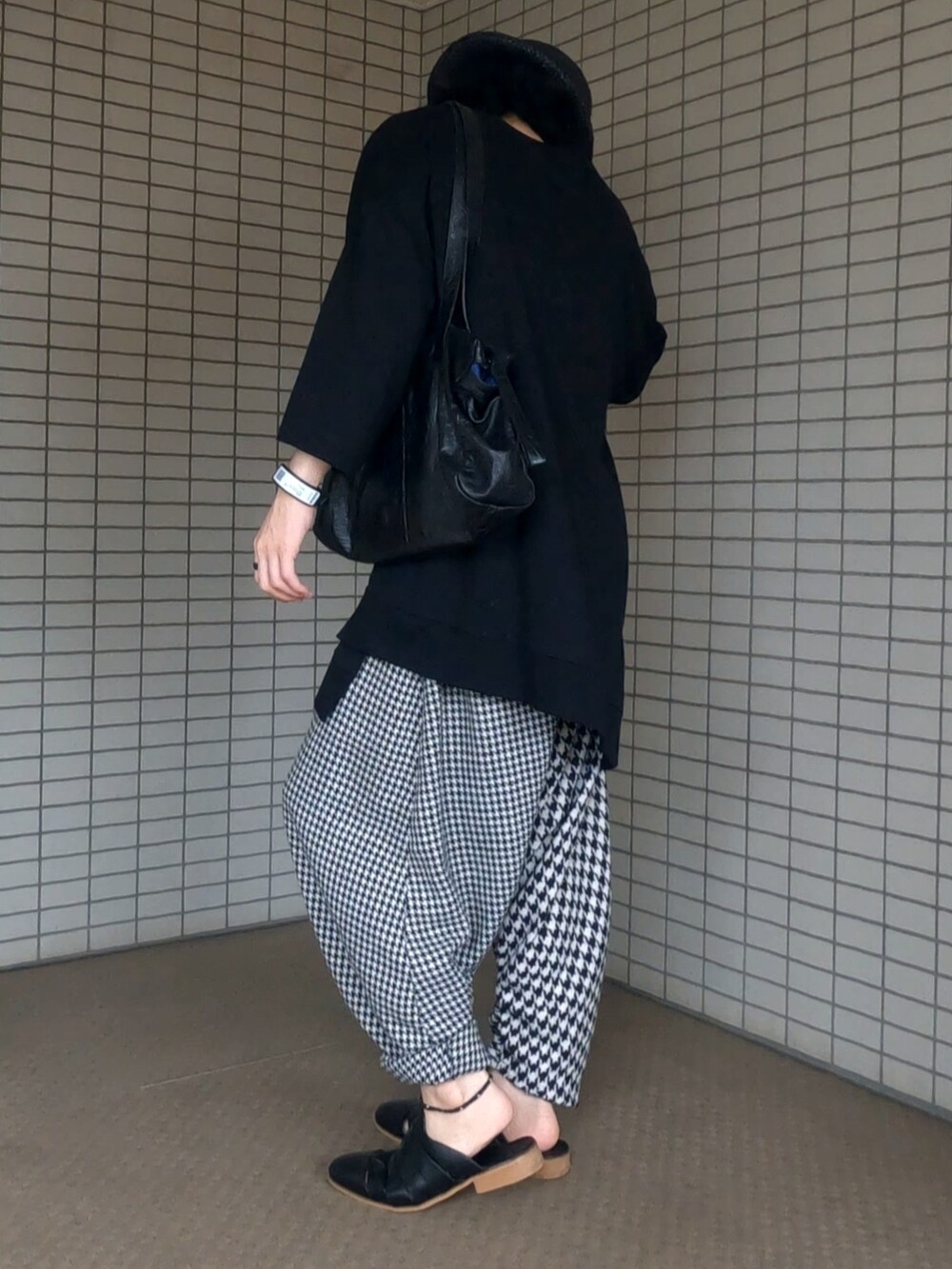 ブラック系のTシャツ/カットソー、ブラック系のボストンバッグ、ホワイト系のパンツを着用したメンズの夏コーディネートの3枚目の写真