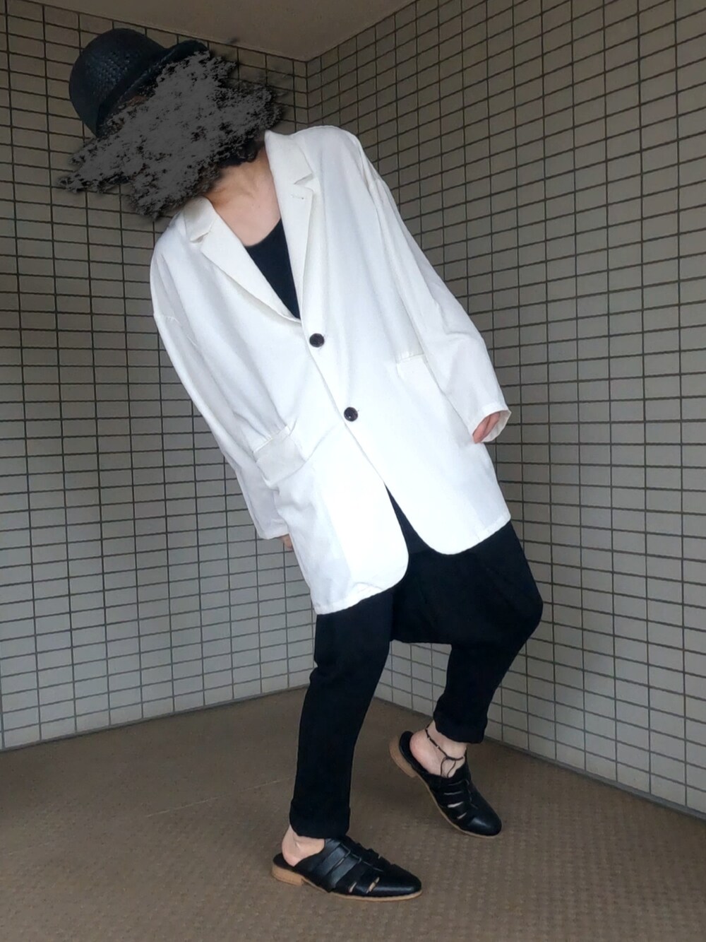 ホワイト系のテーラードジャケット、ブラック系のボストンバッグ、ブラック系のサンダルを着用したメンズの秋コーディネートの4枚目の写真