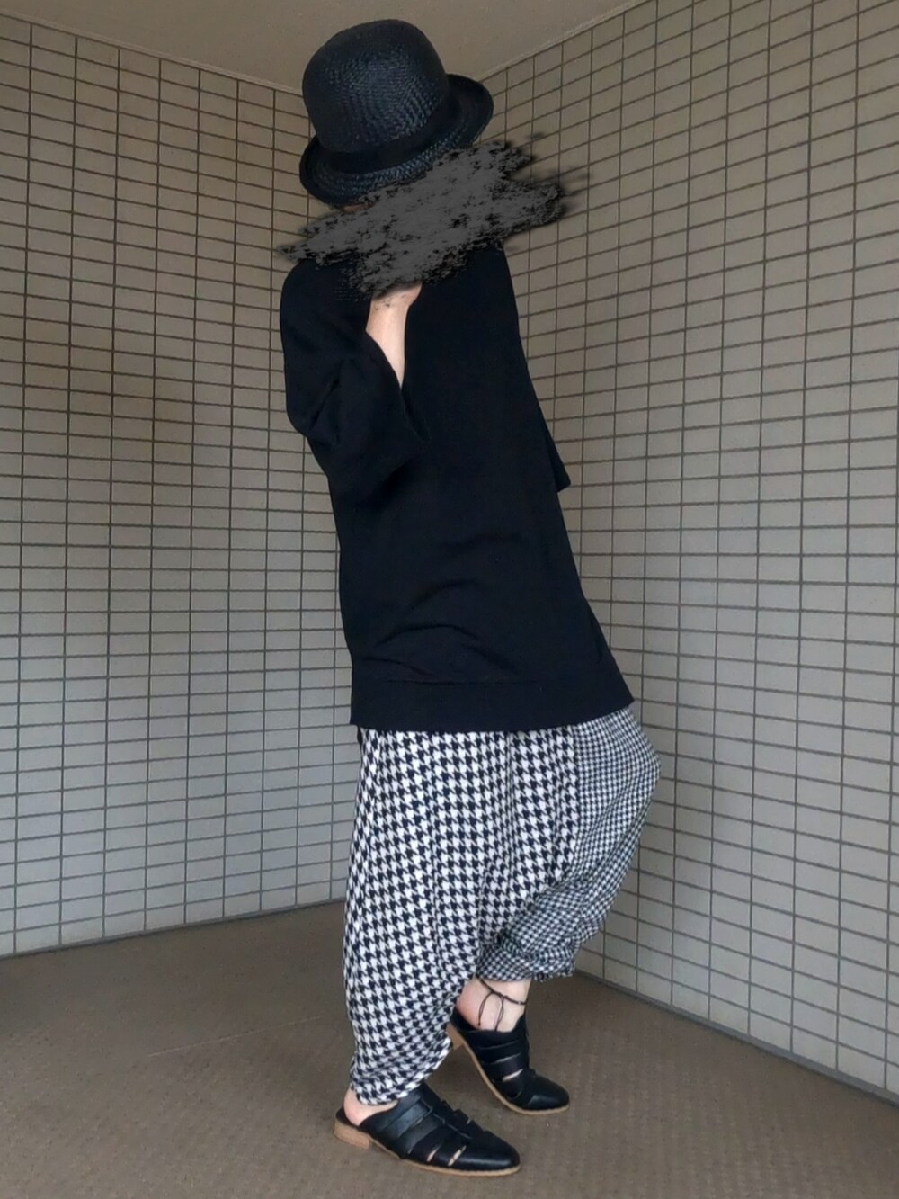 ブラック系のTシャツ/カットソー、ブラック系のボストンバッグ、ホワイト系のパンツを着用したメンズの夏コーディネートの4枚目の写真