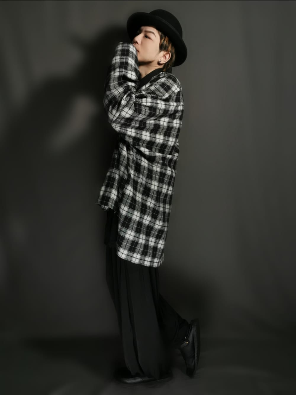 ブラック系のテーラードジャケット、ブラック系のシャツ/ブラウス、ブラック系のスカートを着用したメンズの秋コーディネートの3枚目の写真