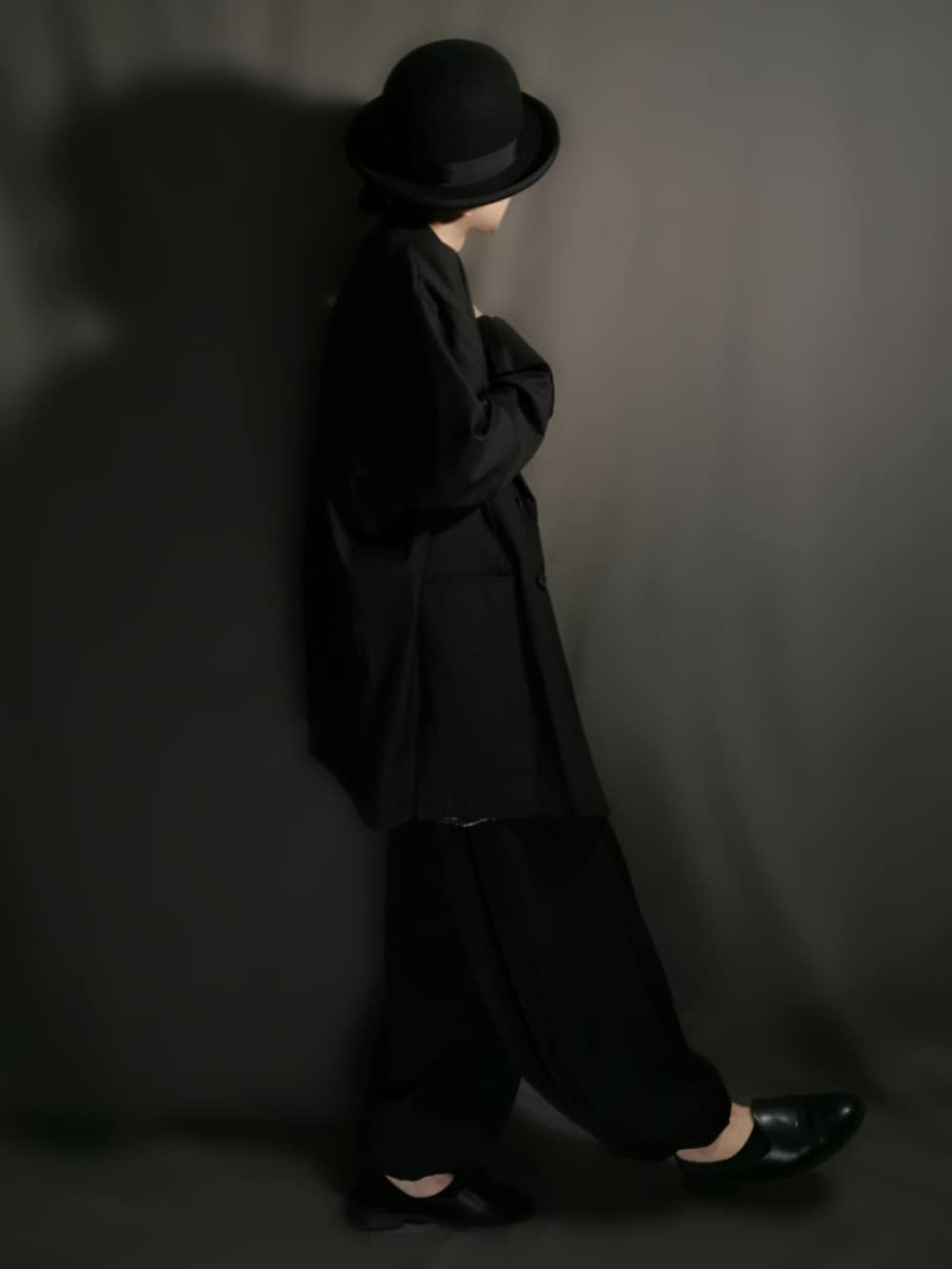 ブラック系のテーラードジャケット、ブラック系のシャツ/ブラウス、ブラック系のスカートを着用したメンズの秋コーディネートの4枚目の写真