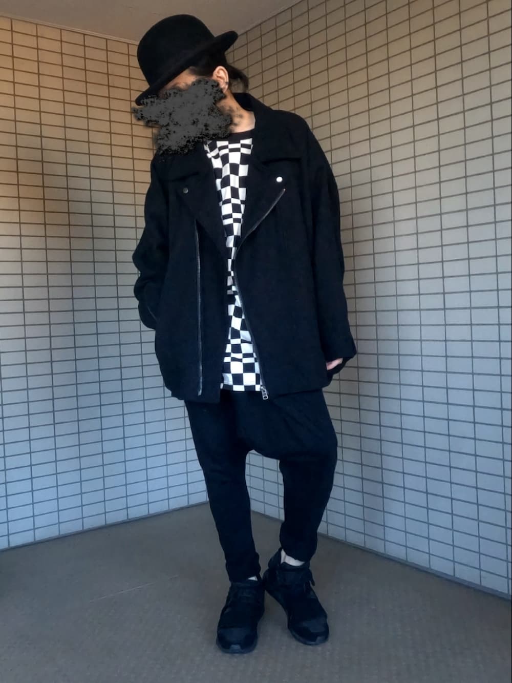 ブラック系のライダースジャケット、ブラック系のスニーカー、ブラック系のクラッチバッグを着用したメンズの冬コーディネートの3枚目の写真