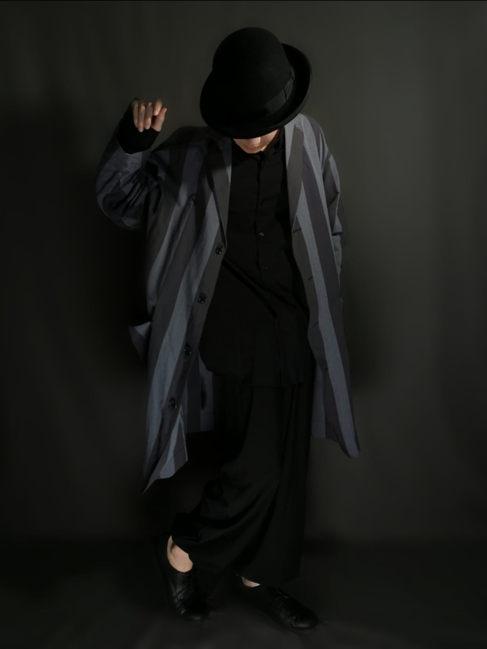 グレー系のチェスターコート、ブラック系のシャツ/ブラウス、ブラック系のセットアップを着用したメンズの秋コーディネートの3枚目の写真