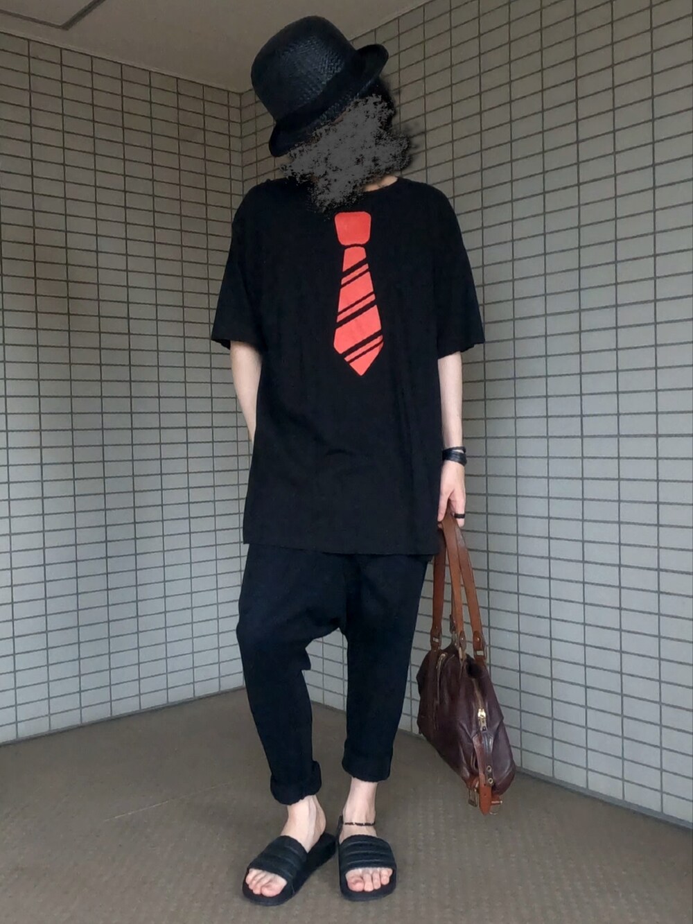 ブラウン系のボストンバッグ、ブラック系のTシャツ/カットソー、ブラック系のその他パンツを着用したメンズの夏コーディネートの4枚目の写真