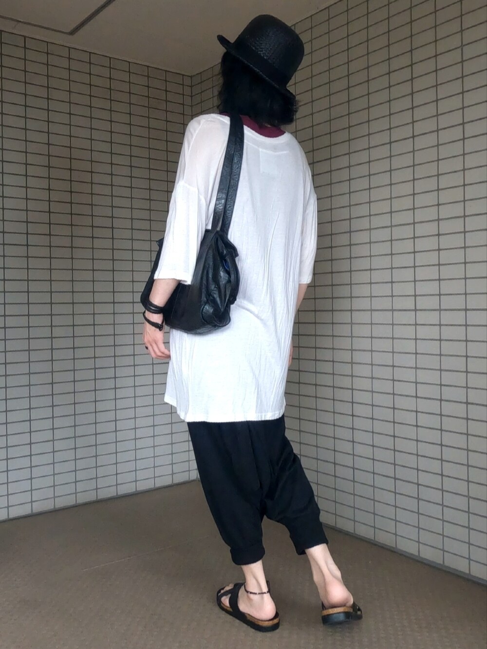 ホワイト系のTシャツ/カットソー、ブラック系のボストンバッグ、ブラック系のその他パンツを着用したメンズの夏コーディネートの4枚目の写真