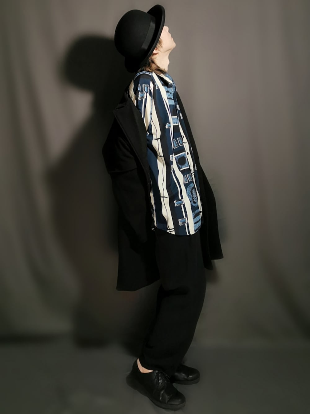 ブラック系のチェスターコート、ブルー系のシャツ/ブラウス、ブラック系のその他パンツを着用したメンズの春コーディネートの3枚目の写真