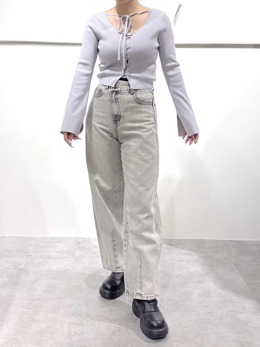 グレー系のニット/セーター、グレー系のデニムパンツを着用したレディースの冬コーディネートの2枚目の写真