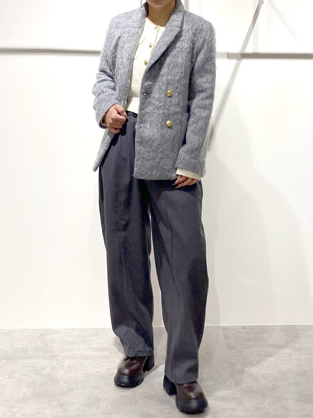 ホワイト系のニット/セーター、グレー系のその他パンツ、グレー系のテーラードジャケットを着用したレディースの冬コーディネートの3枚目の写真