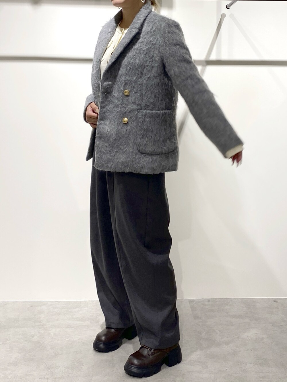 ホワイト系のニット/セーター、グレー系のその他パンツ、グレー系のテーラードジャケットを着用したレディースの冬コーディネートの2枚目の写真