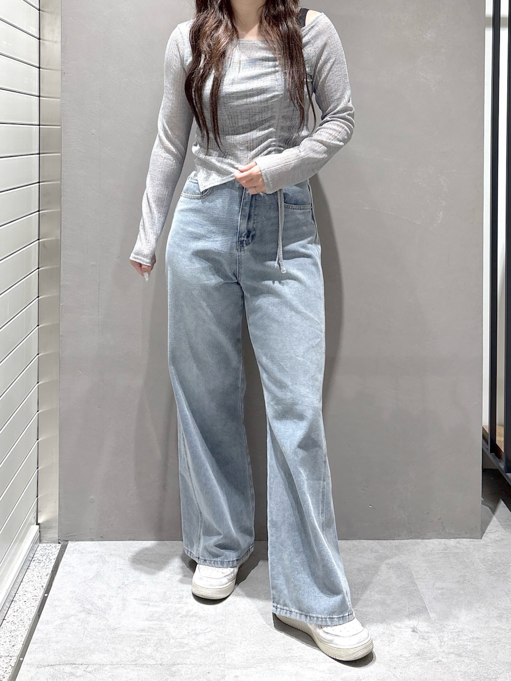 グレー系のTシャツ/カットソー、ブルー系のデニムパンツを着用したレディースの春コーディネートの2枚目の写真