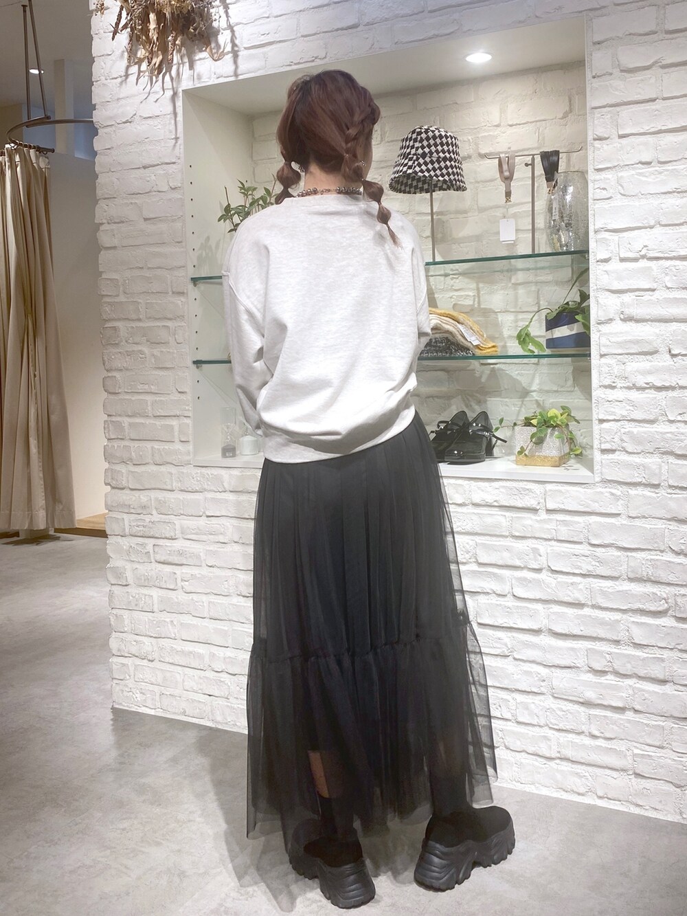 ホワイト系のTシャツ/カットソー、ブラック系のスカートを着用したレディースの秋コーディネートの2枚目の写真
